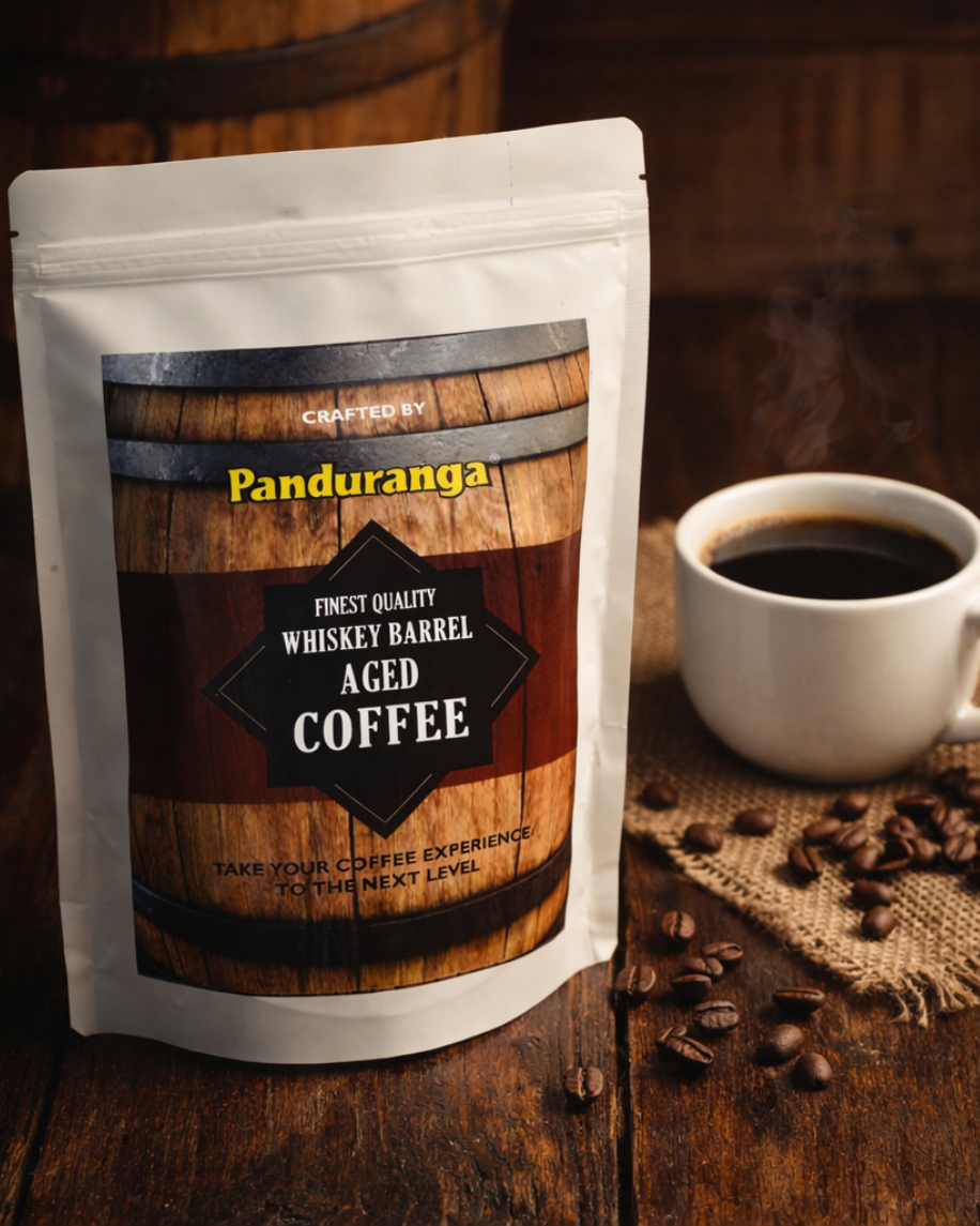 Panduranga whiskey barrel aged coffee package with a cup of coffee and coffee beans on a wooden surface.